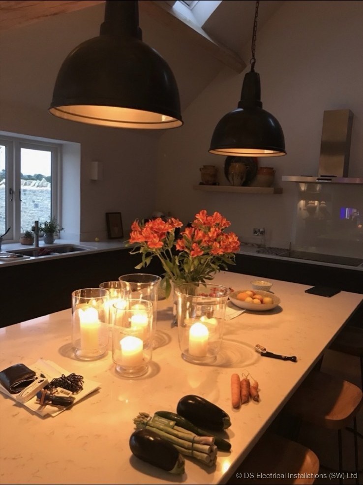 Two large dome pendant lights hung over a quartz kitchen island