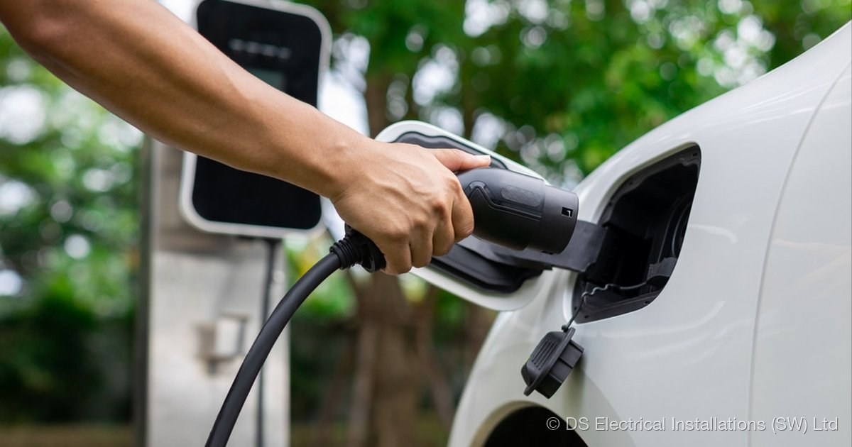 Electric vehicle plugged in to a wall-mounted charge point installed by DS Electrical Installations (SW) Ltd