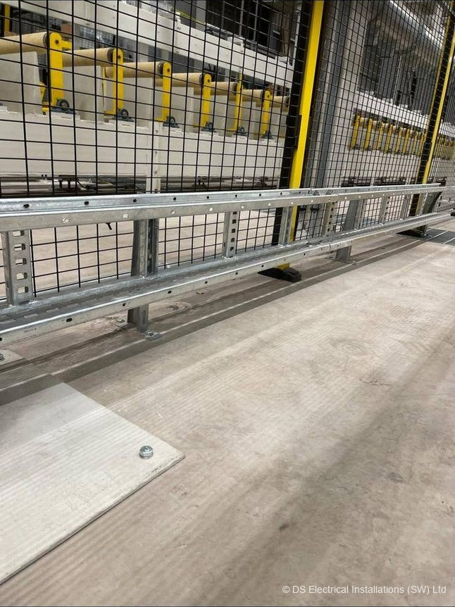 Machine guarding and walkway on a factory production floor during a commercial electrical install