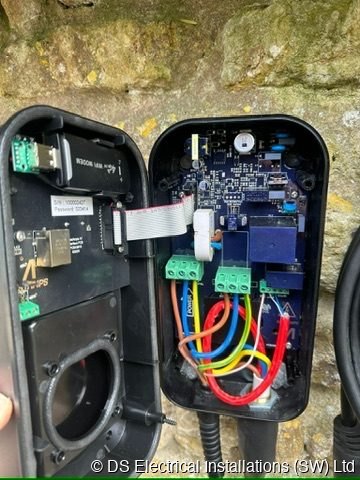 EV charge point opened up showing terminated supply tails and control board before commissioning