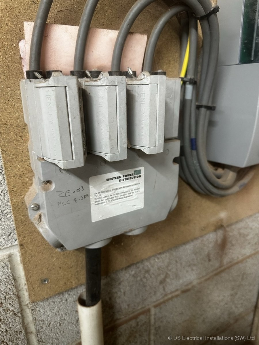Henley block tails splitting the supply beside a sealed DNO service head and cut-out