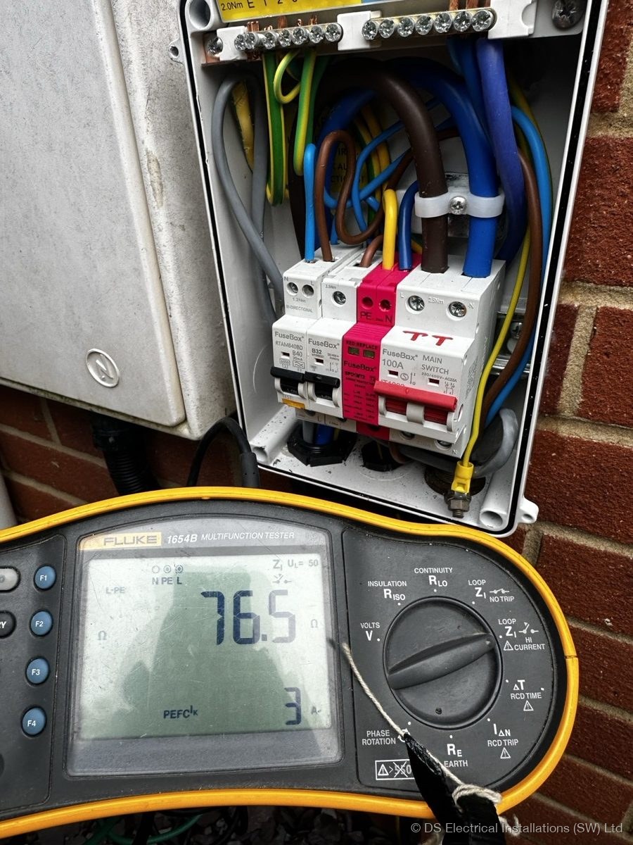 Tester taking a reading at a consumer unit during a landlord inspection