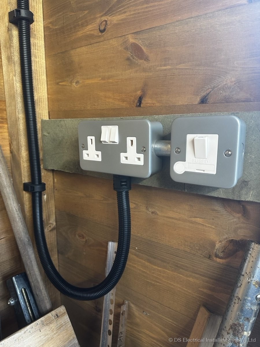 Metalclad twin switched socket and fused spur on flexible conduit in a timber outbuilding
