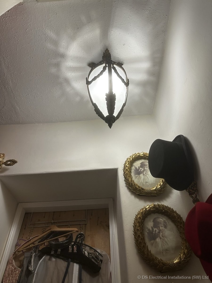 Period wall sconce installed at picture-rail height in the principal bedroom