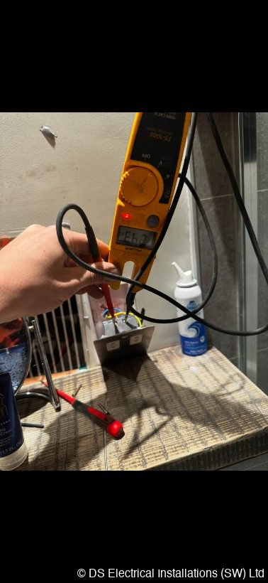Tester taking a reading at a bathroom fitting during an inspection